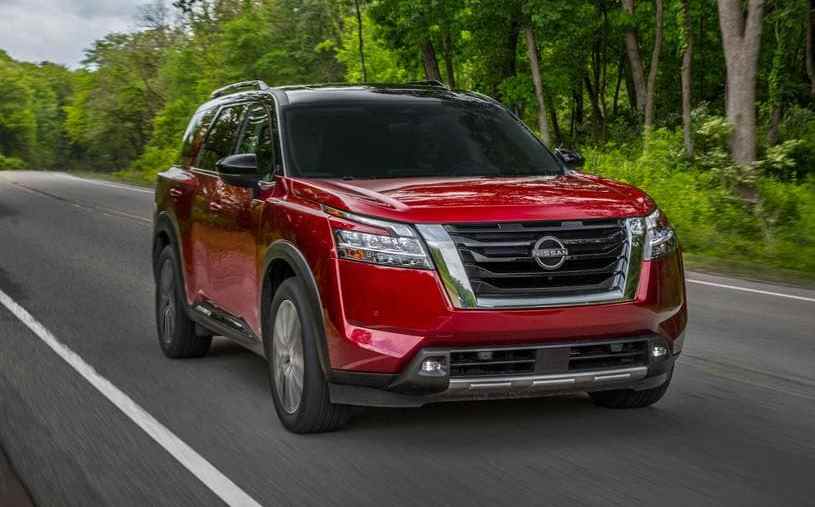 A red 2022 Nissan Pathfinder driving down the road