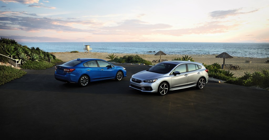 A blue Impreza sedan and a silver wagon on the beach