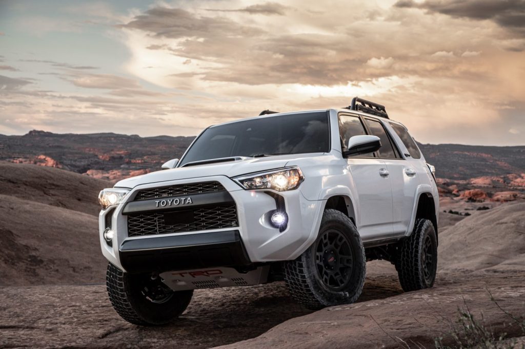 A white 2020 Toyota 4Runner TRD pro SUV climbing rocks on mountain trails