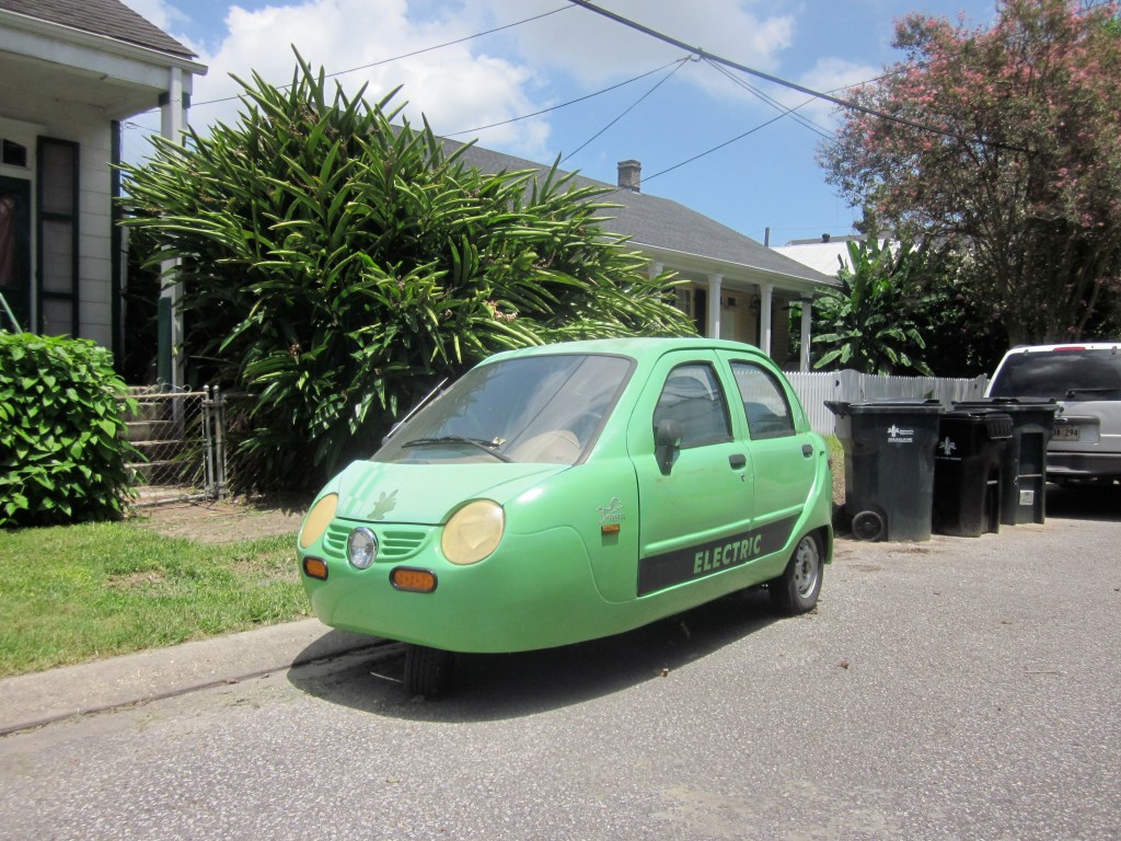 A green ZAP! Xebra parked on the side of the road