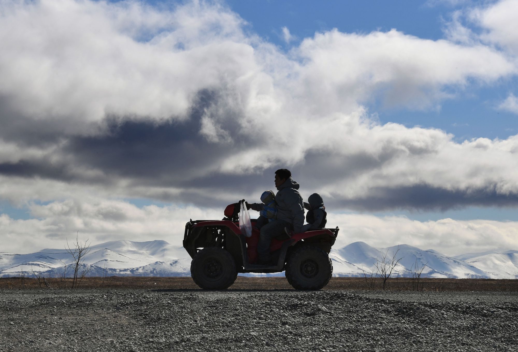 A family rides an ATV near the Yupic Eskimo town of Quinhagak on the Yukon Delta in Alaska on April 12, 2019