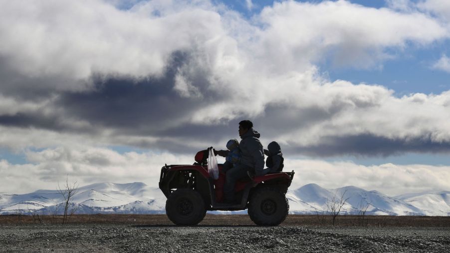 A family rides an ATV near the Yupic Eskimo town of Quinhagak on the Yukon Delta in Alaska on April 12, 2019