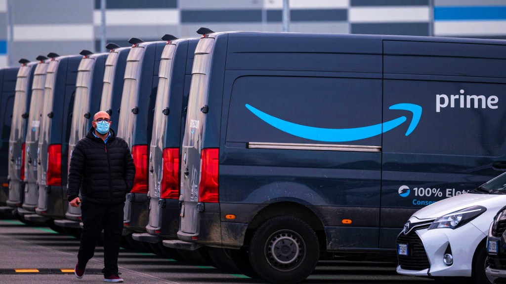 An Amazon employee walks by an Amazon Prime delivery truck in the company's premises.