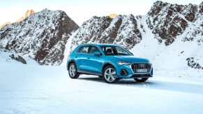 A teal Audi Q3 luxury SUV model parked in a snowy tundra