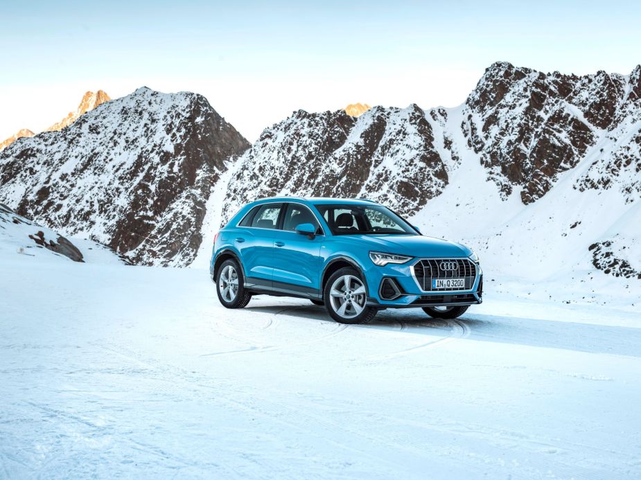 A teal Audi Q3 luxury SUV model parked in a snowy tundra