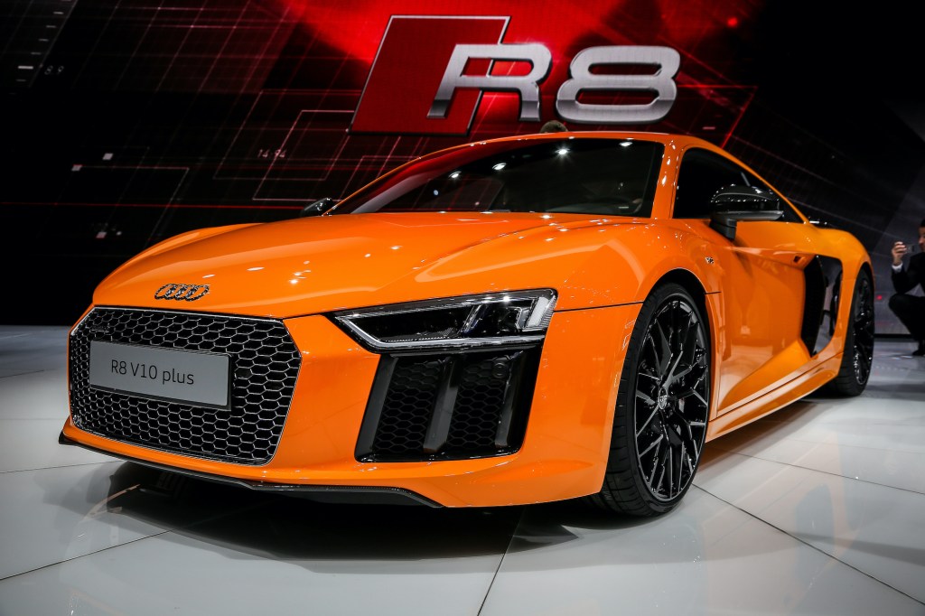 an orange Audi R8 V10 on display at an indoor auto show