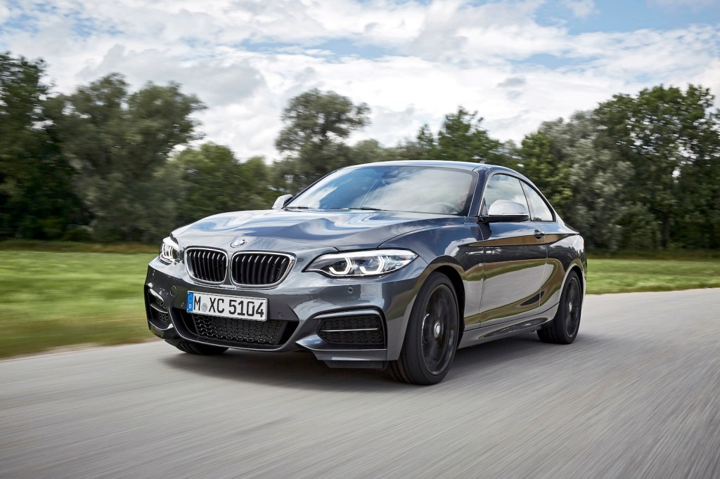 A grey 2021 BMW 2 Series driving along a tree-lined street, the 2 Series is one of the best new cars nobody buys