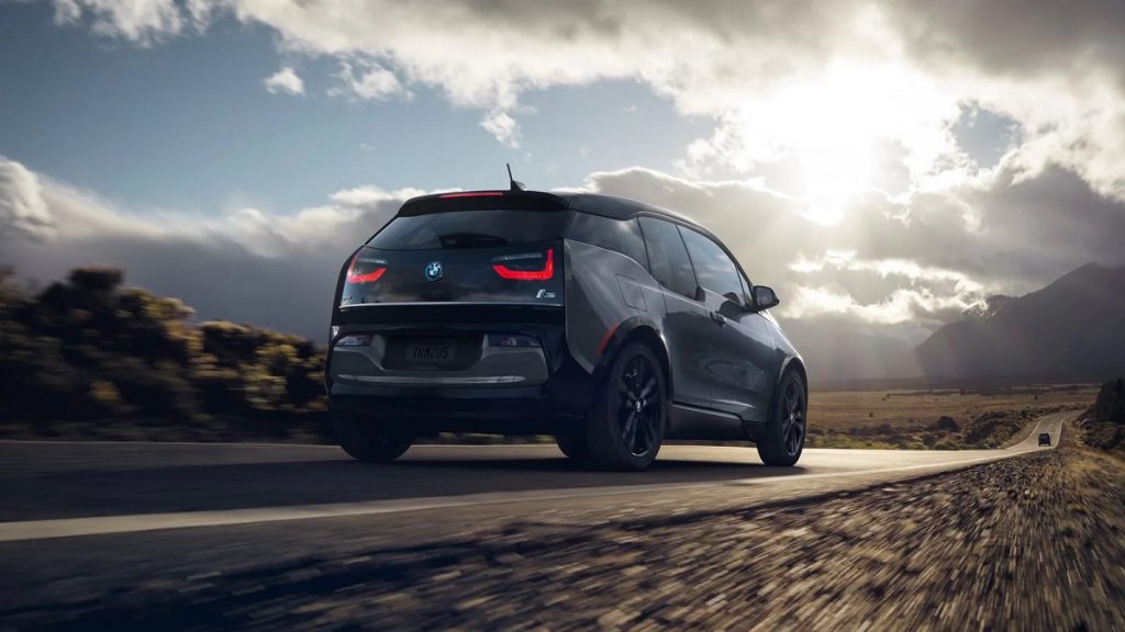 The 2021 BMW i3 drives away on a farmland | BMW