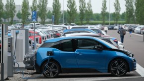A blue BMW i3 electric car charges its battery outside the BMW factory on May 20, 2019, in Leipzig, Germany