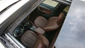An overhead shot of a panoramic sunroof reveals the brown-leather interior of a 2016 BMW X1 xDrive 28i
