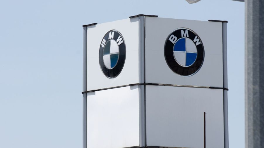 A white BMW marquee tower with BMW's logo shown on the two sides of the marquee visible with a clear sky in the background.