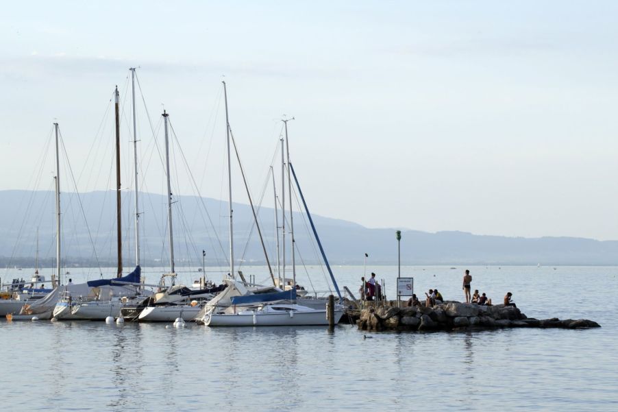A row of sail boats anchored in the middle of a lake
