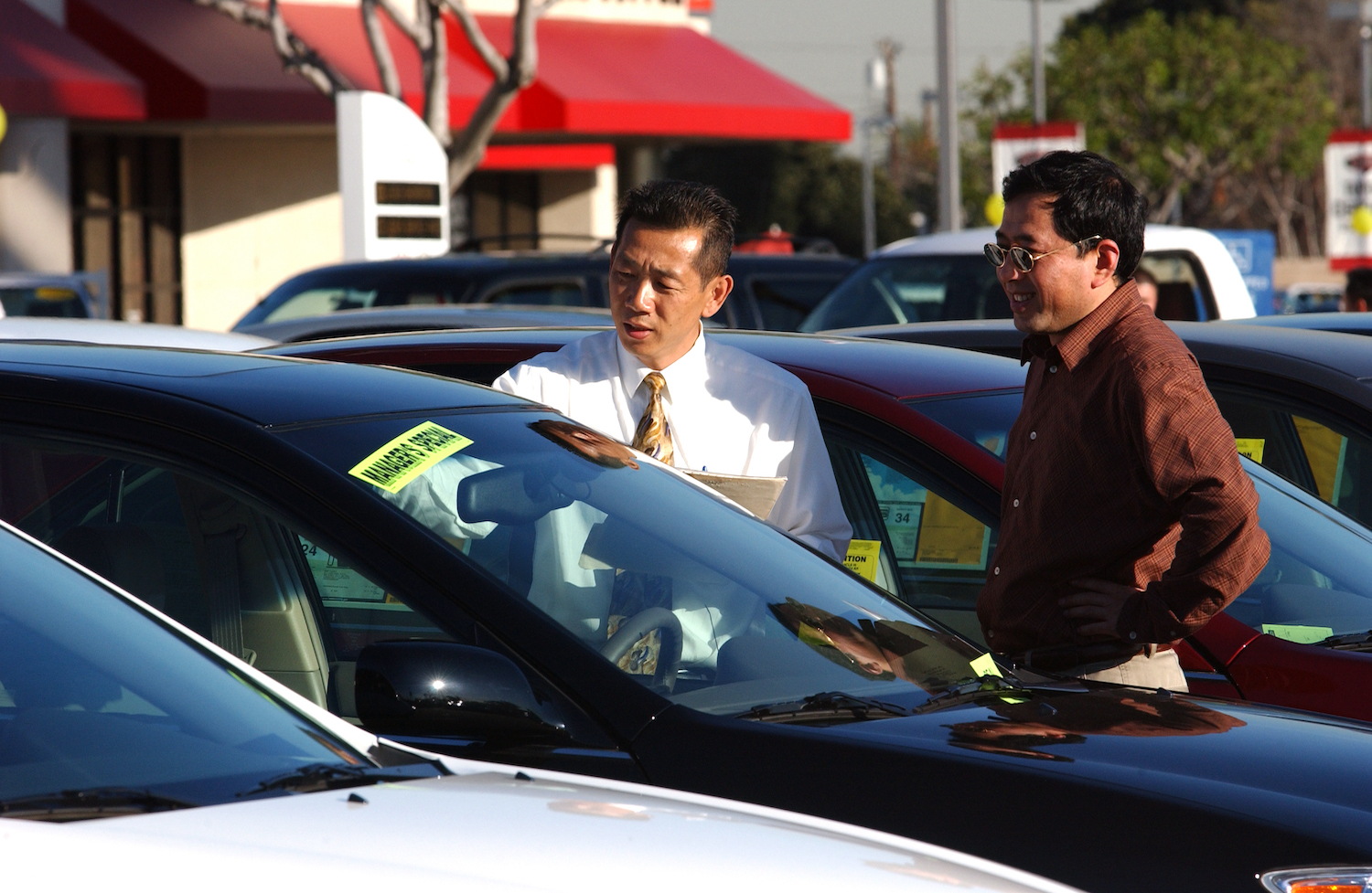 Two men on a car dealership lot