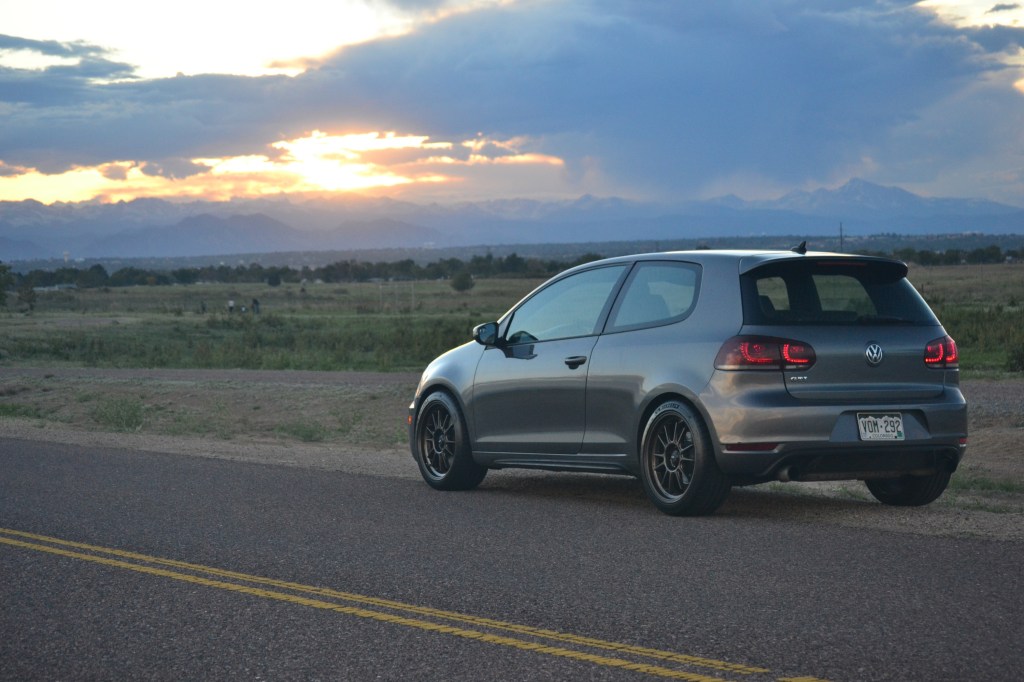 A gray Volkswagen GTI at sunset photographed from the rear 3/4.