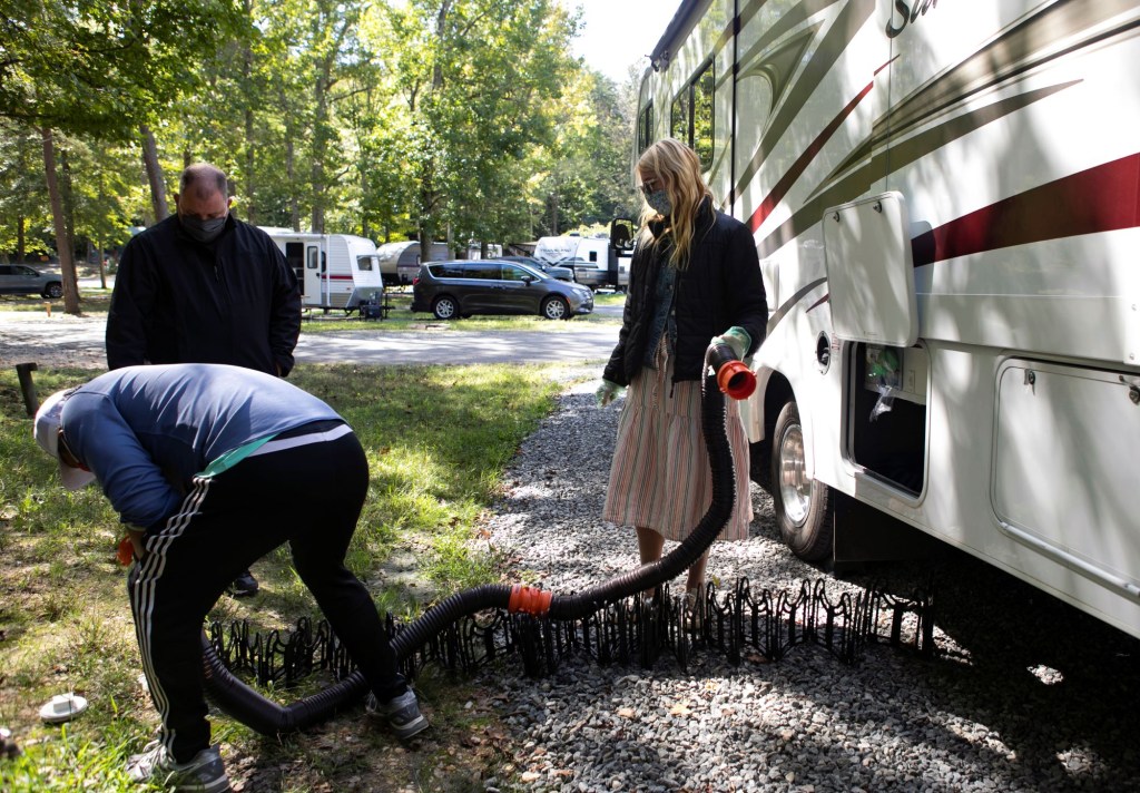 A group of campers dumping sewage water out from an RV