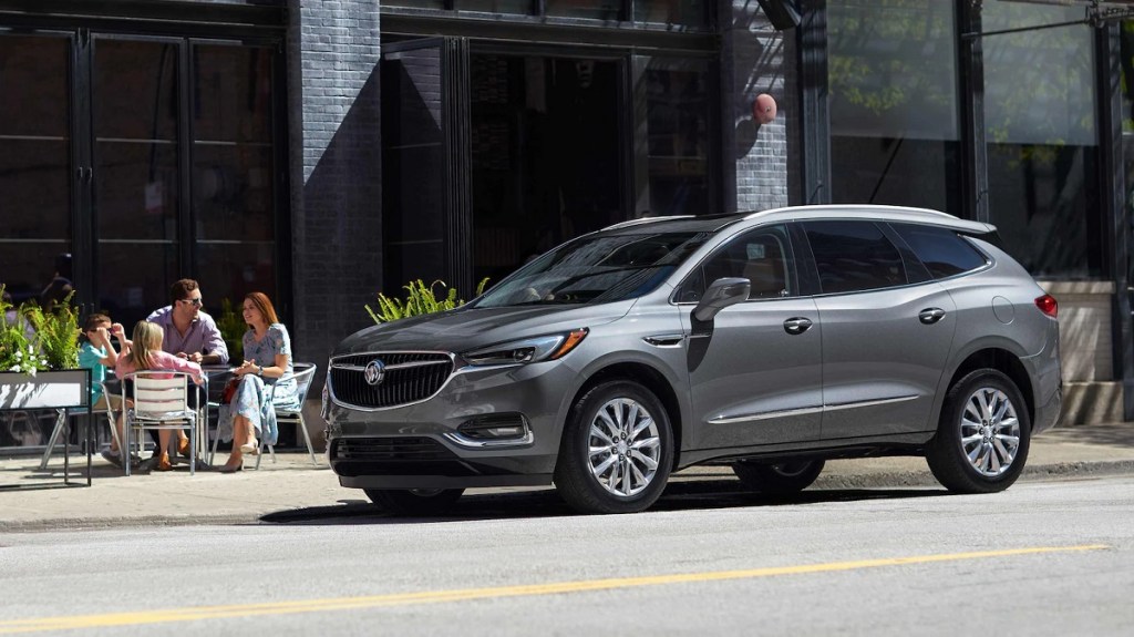 A gray 2021 Buick Enclave parked outside of a restaurant.