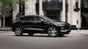 A black 2021 Buick Enclave parked in front of a building.