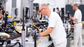 Volkswagen employees wire the battery on a line for the VW ID.3 during a press tour of Volkswagen's Transparent Factory.