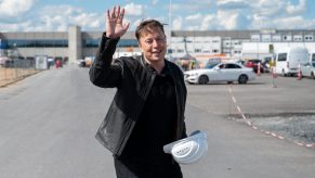 Elon Musk waving in a parking lot