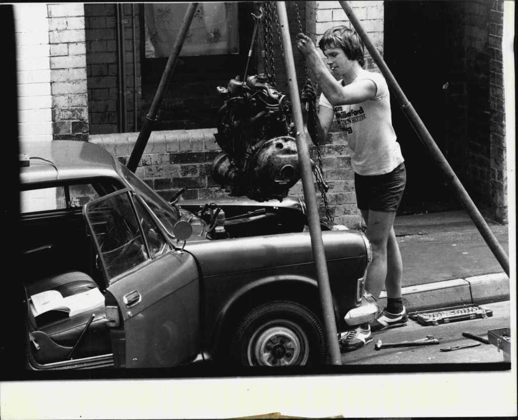 Man pulling engine from car