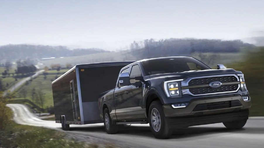 A 2021 Ford F-150 pulling a trailer up a hill.