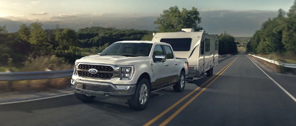 A white 2021 Ford F-150 pulls a trailer.