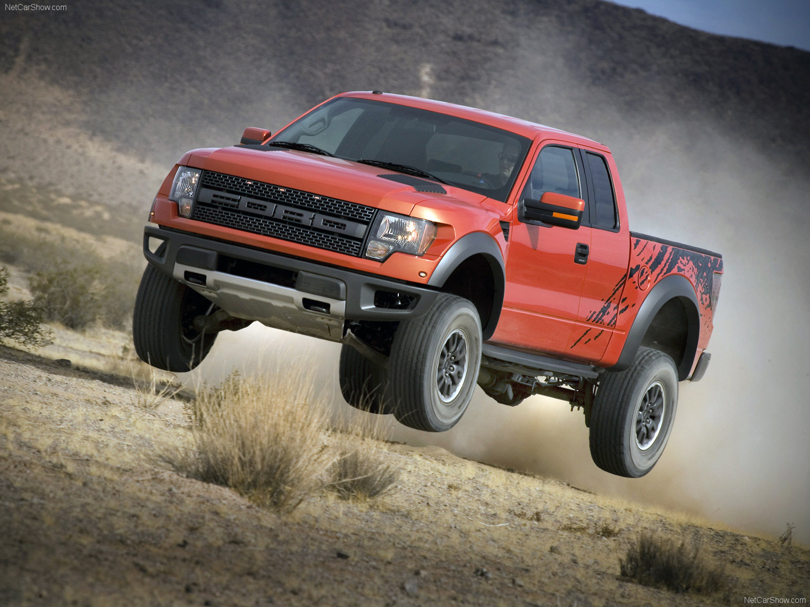 The Ford F-150 Raptor mid jump on a sand dune