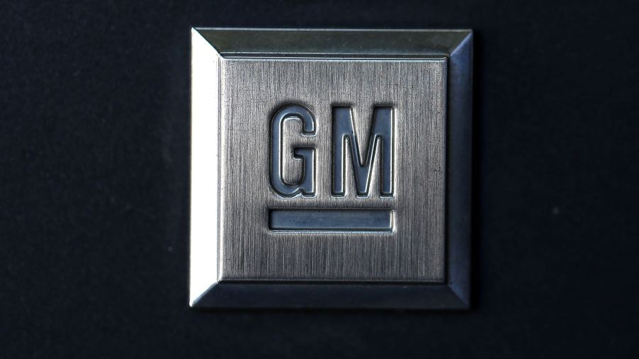 A charcoal grey plaque with the General Motors logo, GM, on it against a black background.