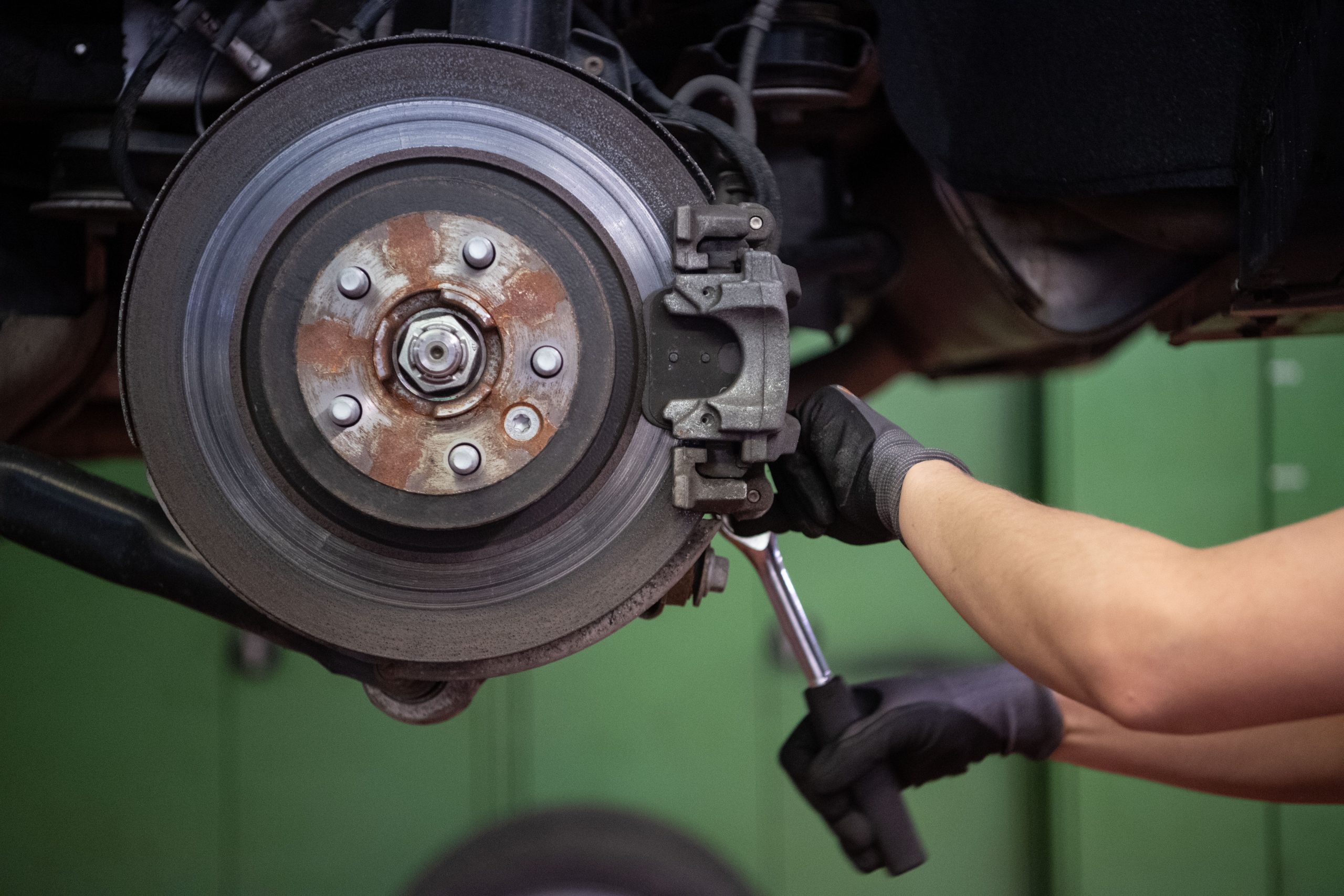 A mechanic performs a brake job in a shop