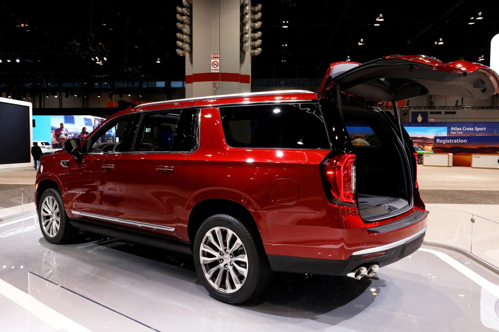 A red Yukon Denali with its tailgate open at an auto show
