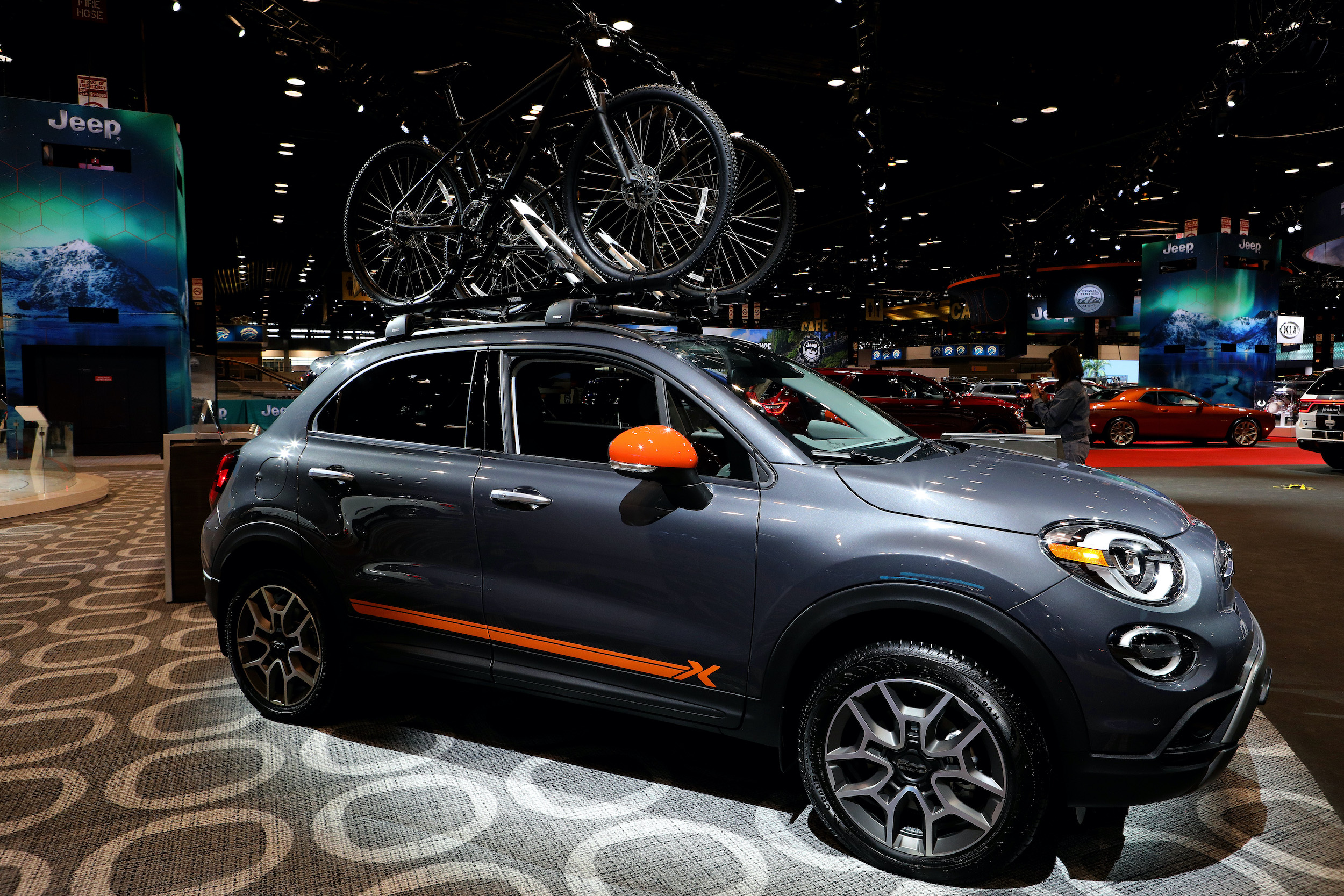 a Fiat 500 X on display with bicycles on top