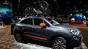 a Fiat 500 X on display with bicycles on top
