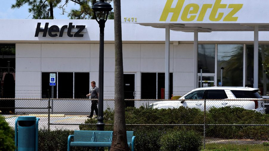 A Hertz rental car agency with palm trees in the foreground