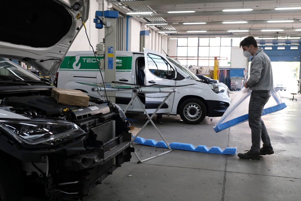 A mechanic works in an auto body shop in Italy