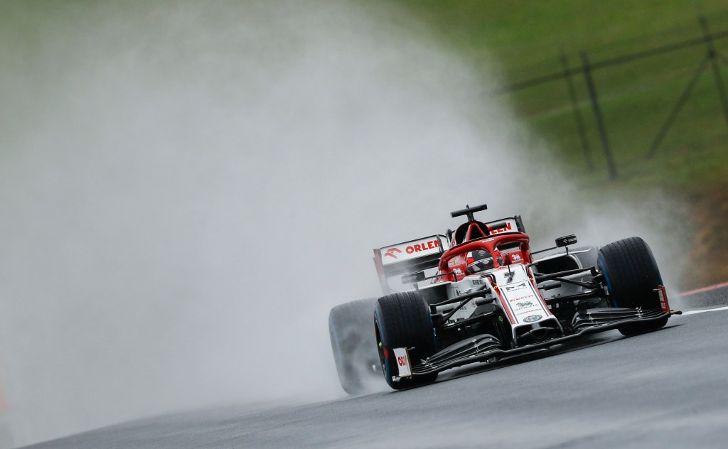 Kimi Raikkonen's F1 car throws rainwater high into the air on a straight