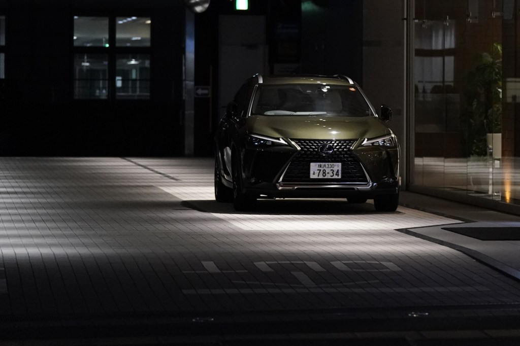 2021 Lexus UX250 parked in the dark on a gray brick paved street