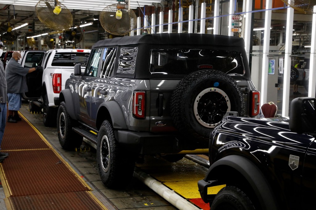 A four-door grey soft-top Ford Bronco on the production line in Michigan