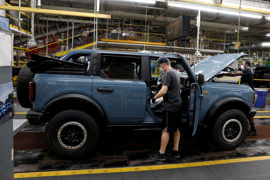 A four-door grey soft-top Ford Bronco on the production line in Michigan
