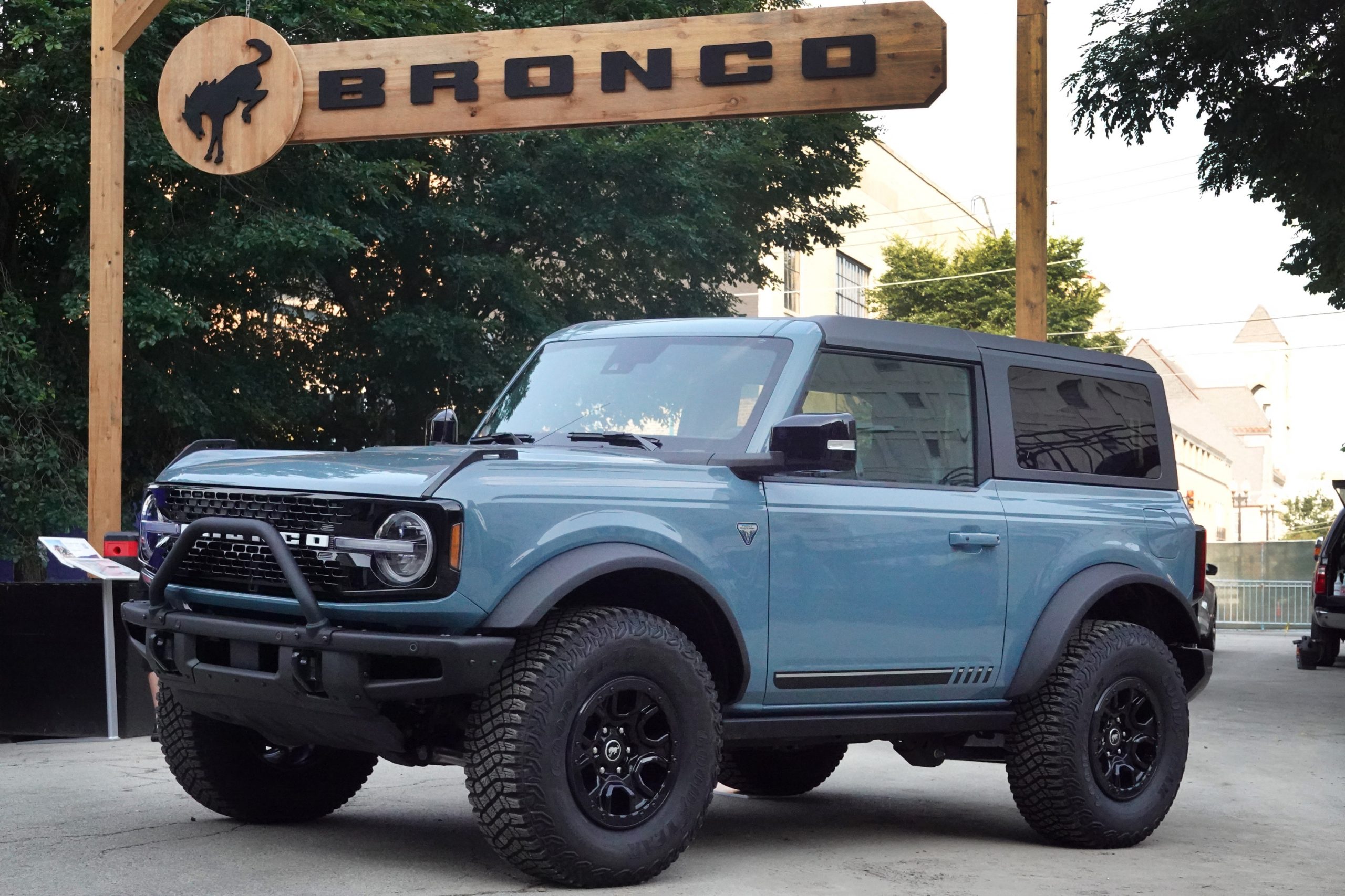 A grey Ford Bronco sits under a sign bearing its name at a press launch