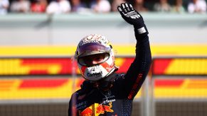 Max Verstappen waves to the crowd at Silverstone, helmet on
