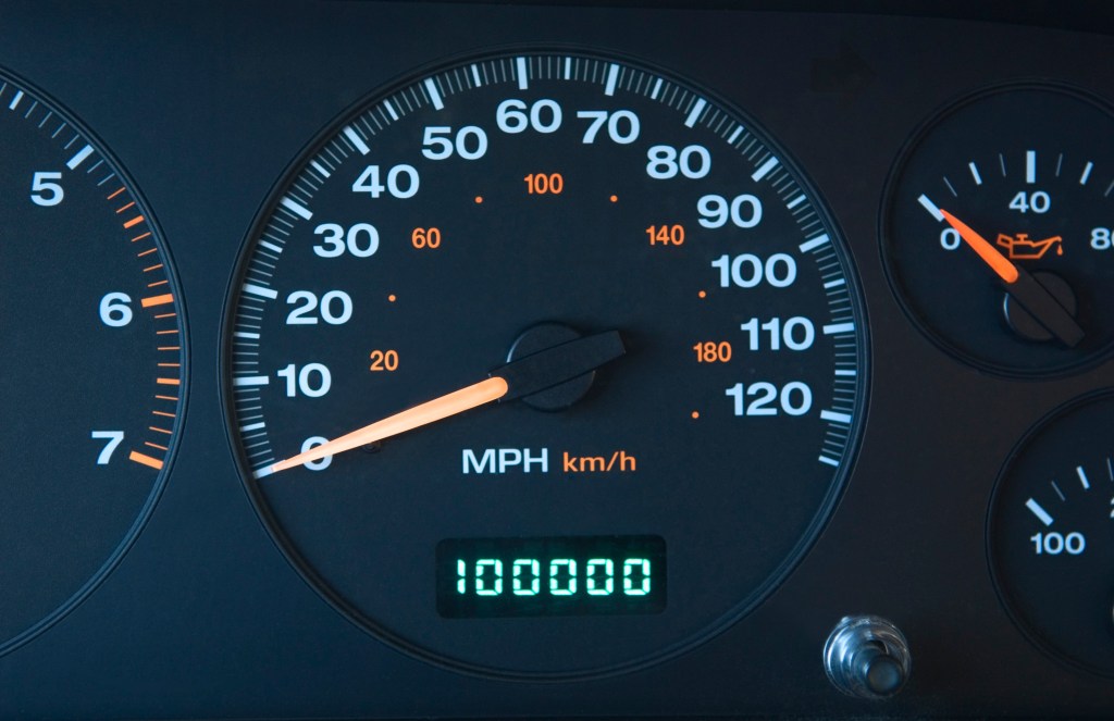 A car's odometer showing 100,000 in mileage