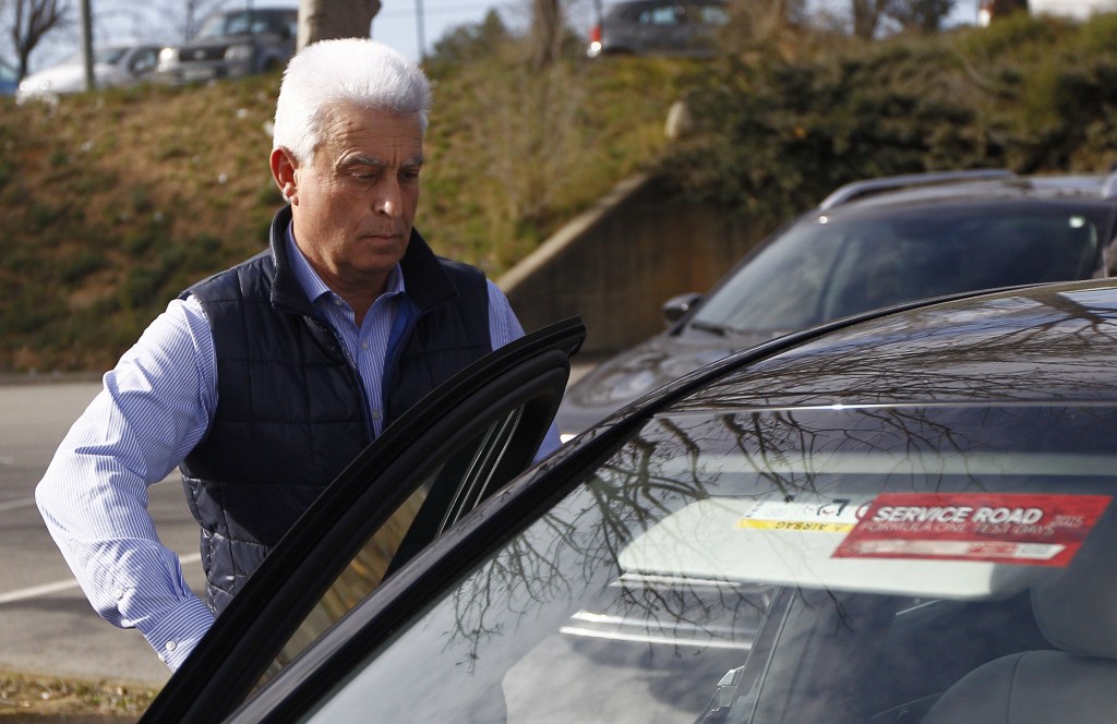 McLaren Honda's Spanish driver Fernando Alonso's father Jose Luis Alonso opens a car door.