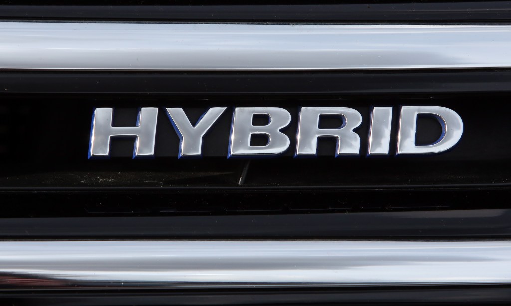 A silver Hybrid Electric Vehicle (HEV) badge
