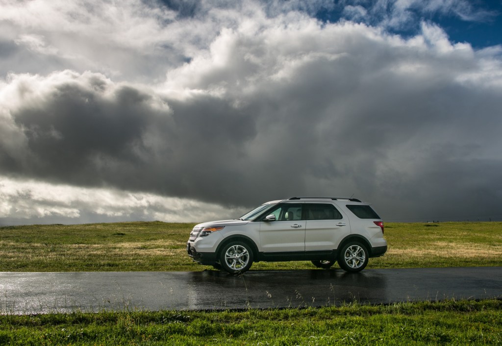 A white Ford Escape SUV on a road wet from recent rain