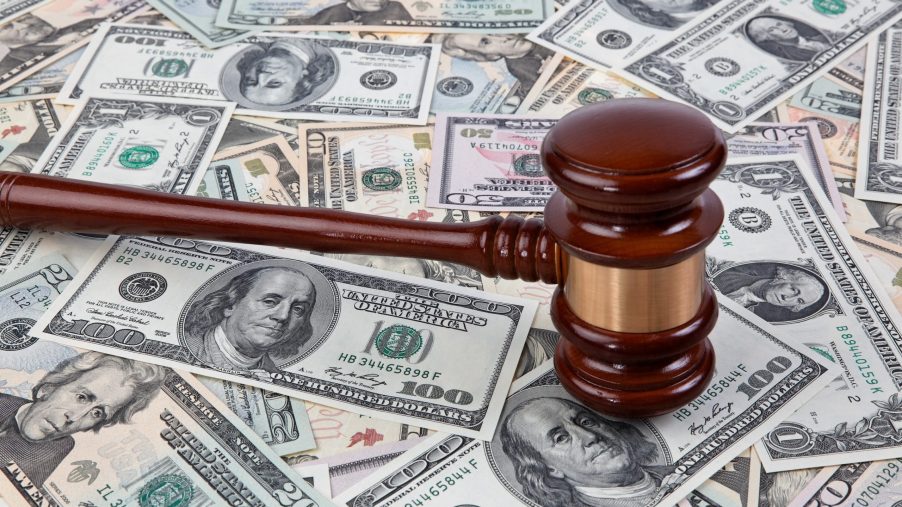 An auction gavel lies on a stack of cash