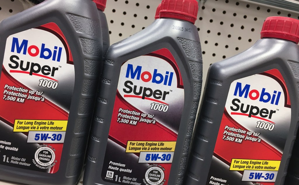 Mobil Super motor oil bottles on a hardware store shelf.