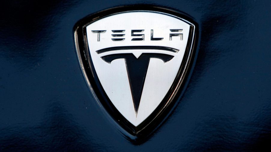 Tesla's logo seen on the fender of one of their models, painted dark blue