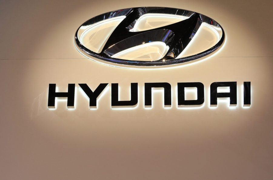 A black Hyundai logo against a beige background
