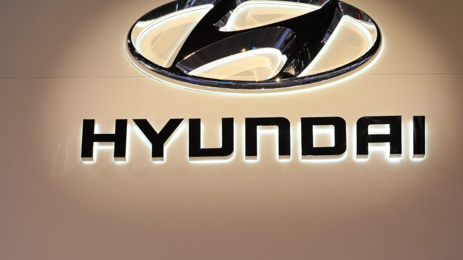 A black Hyundai logo against a beige background