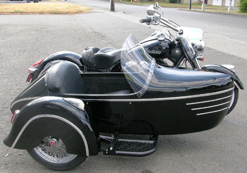 The side view of a black Indian Vintage with a black-and-chrome DMC Tomahawk sidecar